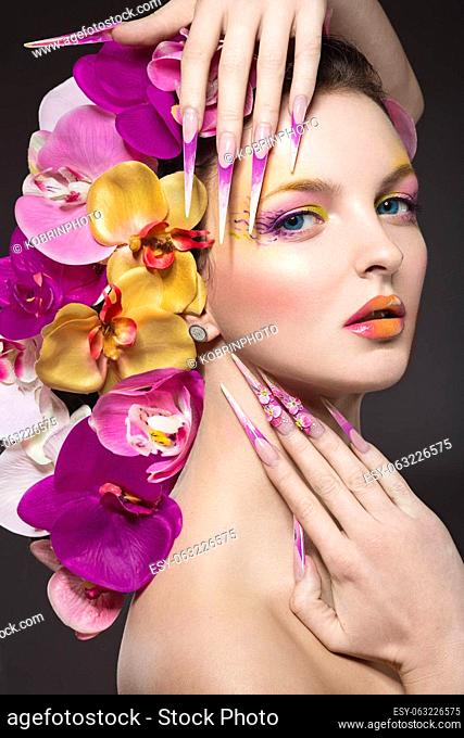 Beautiful woman with long nails, perfect skin, hair of orchids. Portrait shot in the studio