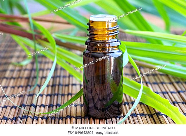 A bottle of essential oil with fresh lemon grass