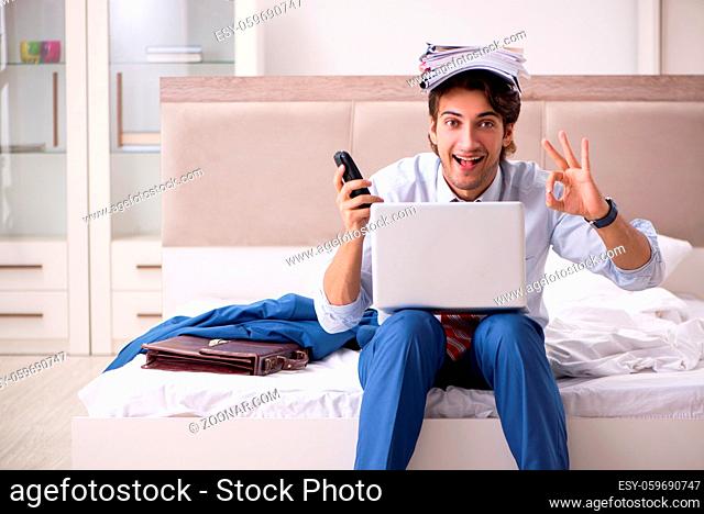 Young employee working at home sitting on the bed