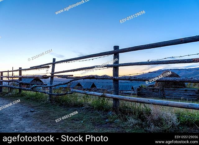 wooden fence on xinjiang baihaba village in sunset, primitive natural village landscape