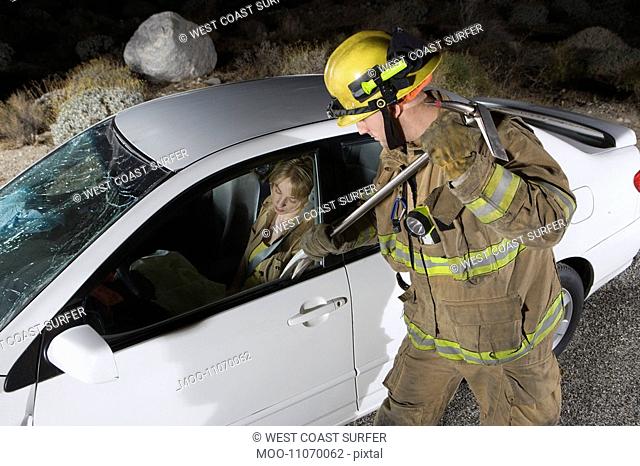 Firefighter rescuing car accident victim
