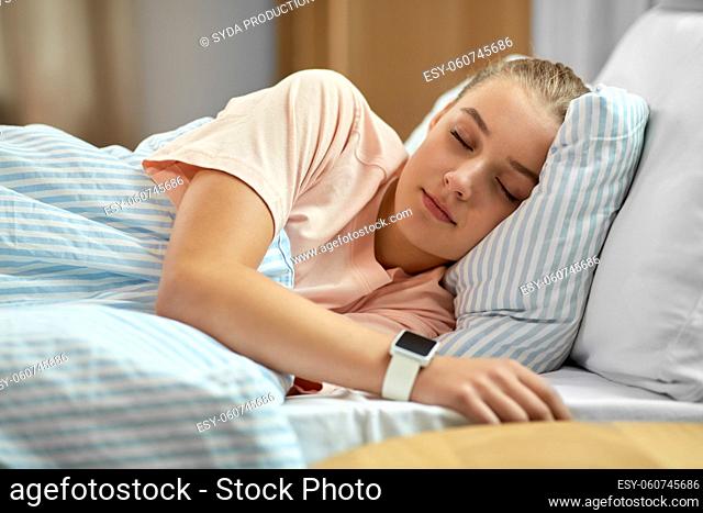 girl with smart watch sleeping in bed at home