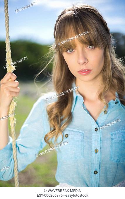 Natural young woman sitting on swing