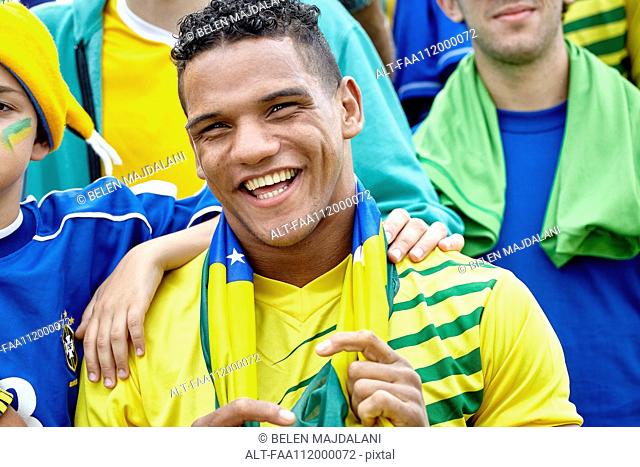 Brazilian football fan smiling cheerfully at match
