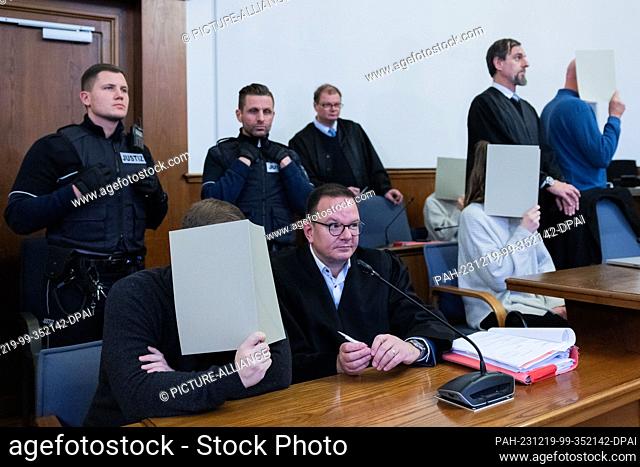 PRODUCTION - 19 December 2023, North Rhine-Westphalia, Dortmund: The five accused police officers surrounding the shooter (l) sit between their lawyers in the...