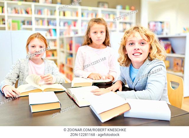 Gruppe Schüler der Grundschule lernt als Team zusammen in der Bibliothek