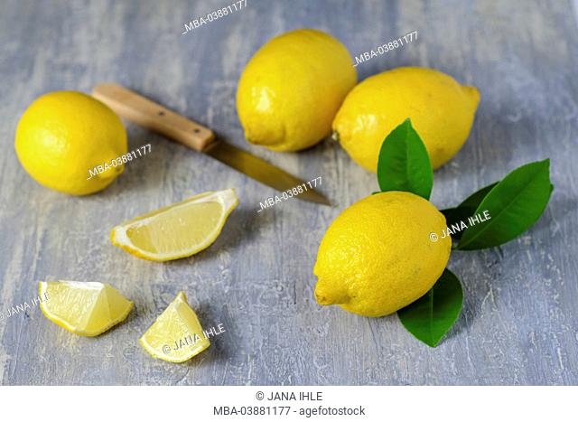 Whole and sliced lemons on grey subsoil