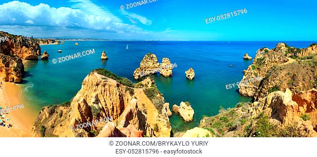 Ponta da Piedade (group of rock formations along coastline of Lagos town, Algarve, Portugal). People are unrecognizable. Two shots stitch panorama
