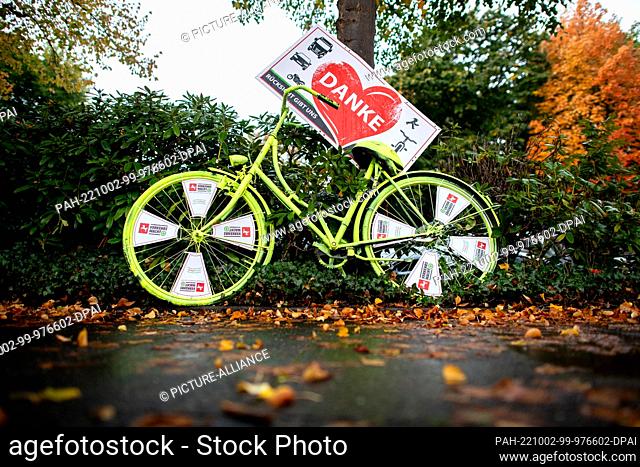 02 October 2022, Lower Saxony, Oldenburg: A neon yellow bicycle belonging to the Lower Saxony traffic watch group, with a sign reading ""Thank you -...