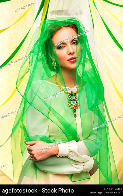 beautiful young woman with red hair in green veil with crystal stone accessories. spring bride