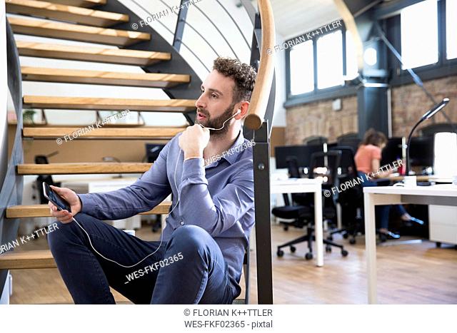 Man in modern office chatting on cell phone