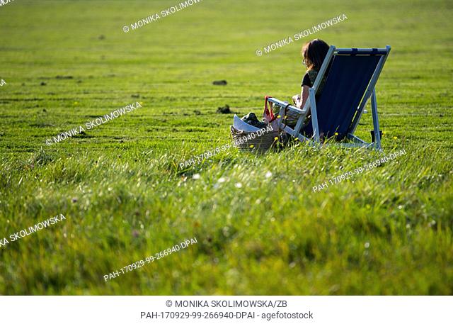A woman enjoys a sunbath in the Fuerst-Pueckler-Park in Bad Muskau, Germany, 29 September 2017. Photo: Monika Skolimowska/dpa-Zentralbild/ZB