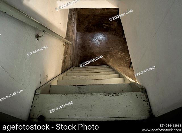 empty basement in abandoned old industrial building with little light and a wooden stairs darkness