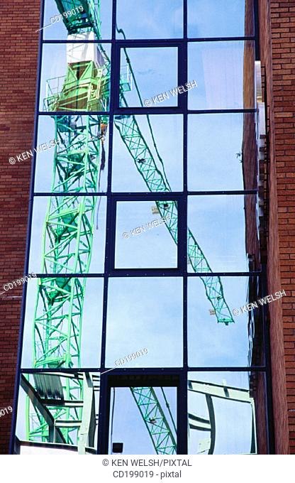 Construction crane reflected in window
