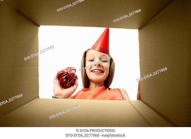 birthday girl in party hat looking into gift box