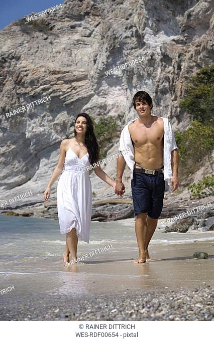 Asia, Thailand, Young couple walking hand in hand along beach