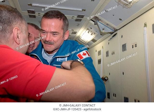 Canadian Space Agency astronaut Chris Hadfield greets two Russian cosmonauts onboard the International Space Station moments after coming aboard on Dec
