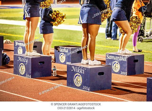 Cheerleaders stand on personalized platforms during a night high school football game in San Juan Capistrano, CA