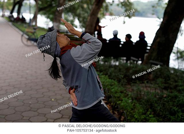 Woman do Tai Chi in the morning on the banks of Hoan Kiem Lake. Hanoi. Vietnam. | usage worldwide. - Hanoi/Hanoi/Vietnam
