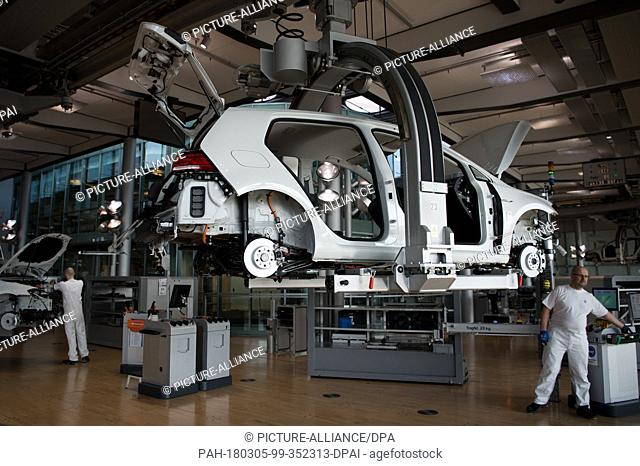 05 March 2018, Germany, Dresden: An employee works on the VW e-Golf assembly line at the 'Glaeserne Manufaktur' Transparent Factory