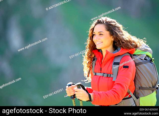 Happy hiker in red walking in the mountain with blurred background