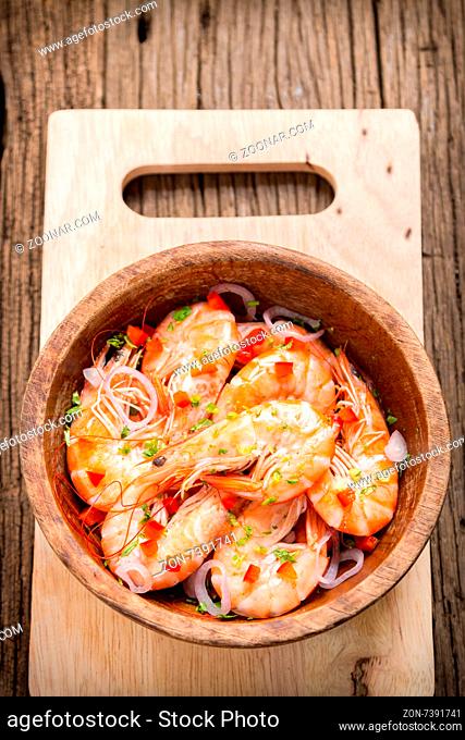 steamed shrimps in a wooden bowl on wood background