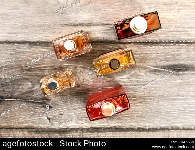 Tabletop view, men fragrances colourful bottles, on wooden boards desk