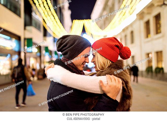 Romantic young couple hugging on street at xmas, London, UK