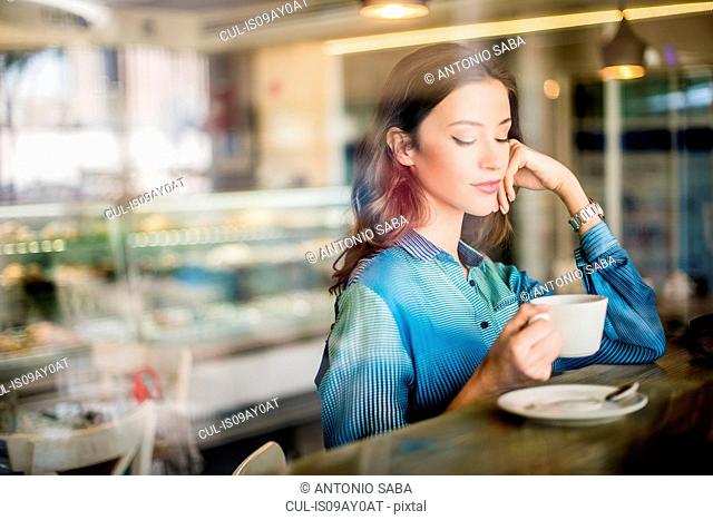 Beautiful woman at cafe window seat, Dubai, United Arab Emirates