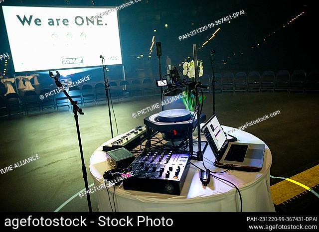 20 December 2023, Hamburg: Microphones, sound and image technology stand in front of the event logo. Almost 100 very different people have created a mandala...