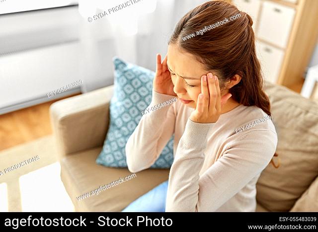 sick asian woman having headache at home