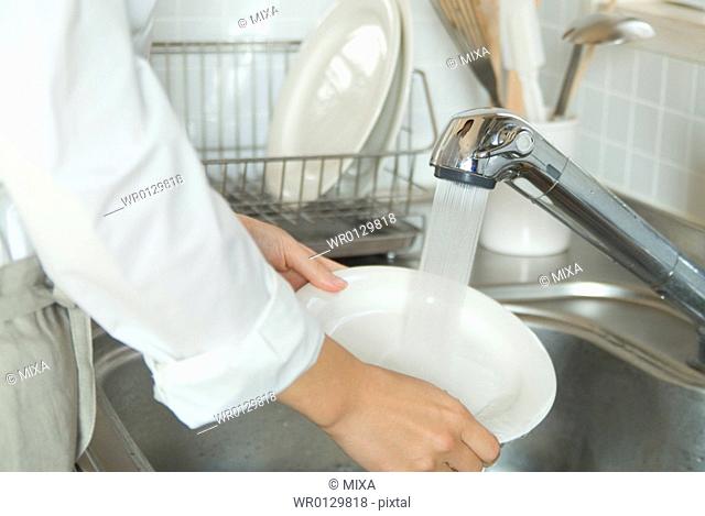 Washing dishes in kitchen sink