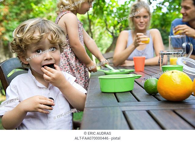 Boy enjoying outdoor snack with his family