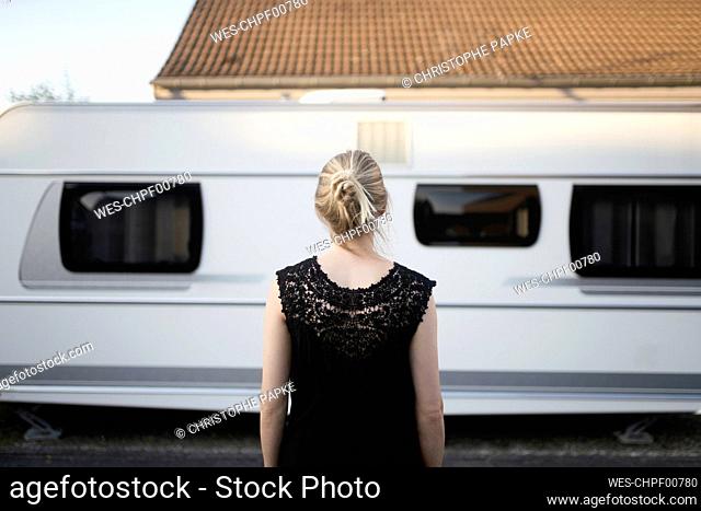 Blond woman in front of camper trailer