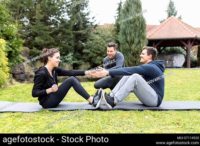 Couple trains with personal trainer in the garden