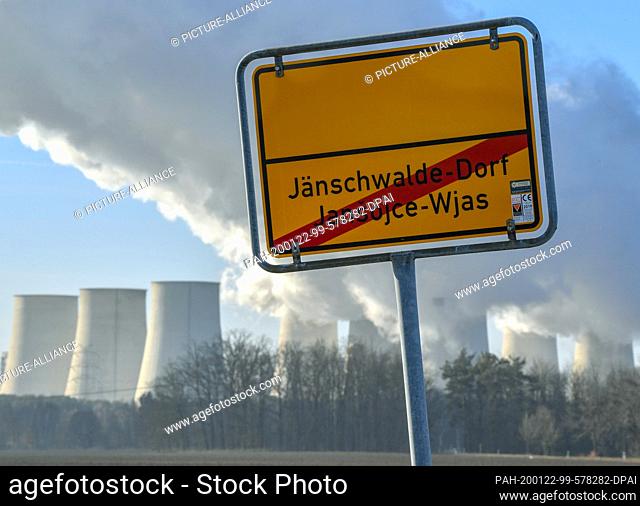 21 January 2020, Brandenburg, Jänschwalde-Dorf: The exit sign of the Lusatian community of Jänschwalde-Dorf, in the background the steaming cooling towers of...