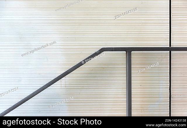 The railing and the fugue in front of a plain gray wall