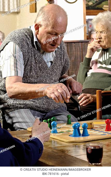 Senior citizens playing a board game in a nursing home