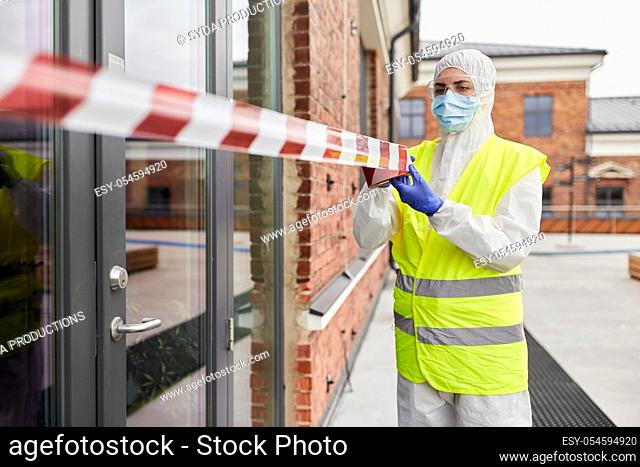 healthcare worker sealing door with caution tape