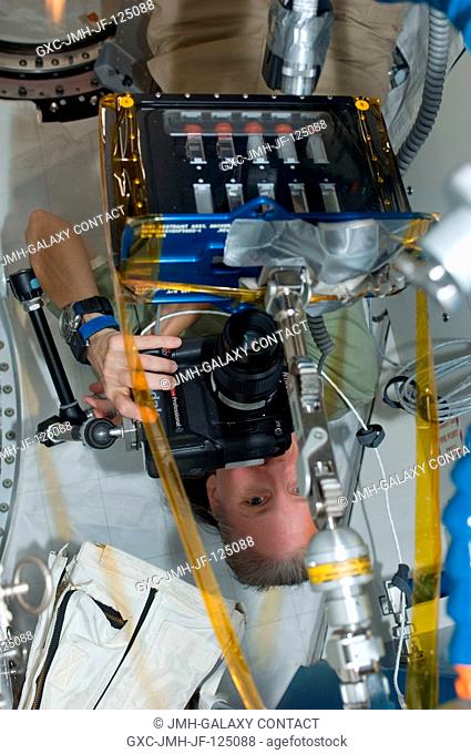 NASA astronaut Shannon Walker, Expedition 25 flight engineer, uses a digital still camera to photograph Binary Colloidal Alloy Test-5 (BCAT-5) experiment...