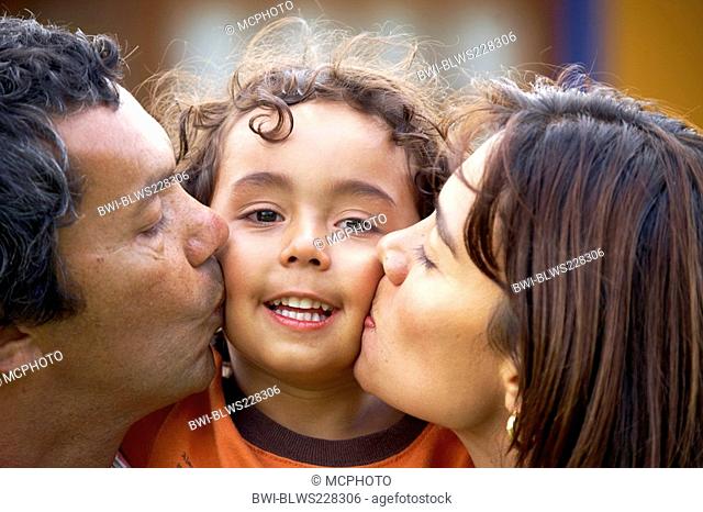 family portrait kissing their little son
