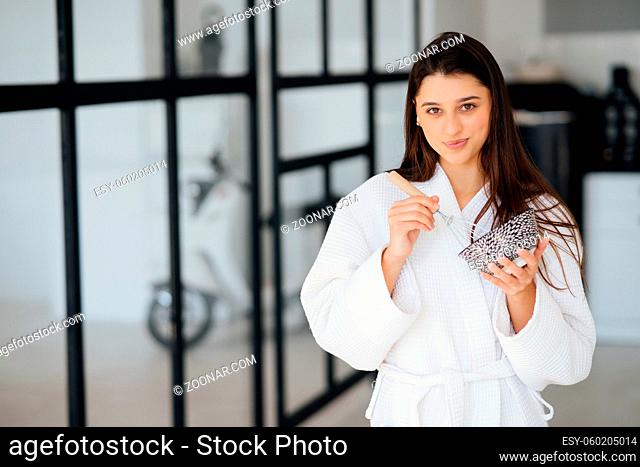 Elegant woman in white coat posing in the kitchen