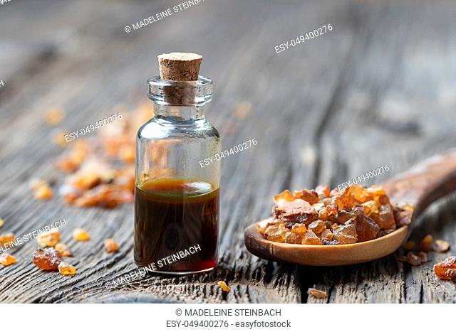 A bottle of essential oil with myrrh resin on a spoon