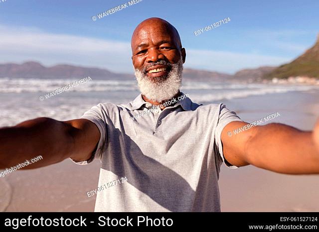 Portrait of african american man taking a selfie on the beach