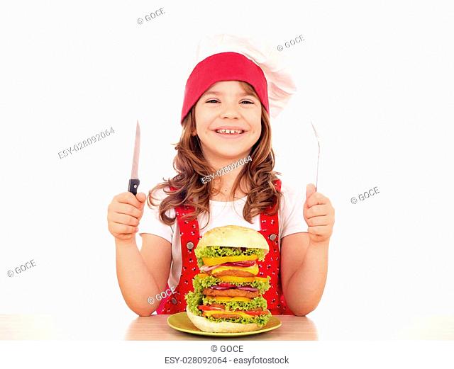 happy little girl cook with big hamburger on table