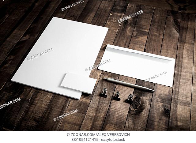 Photo of blank stationery set on wooden table background. Responsive design mockup. ID template. Top view