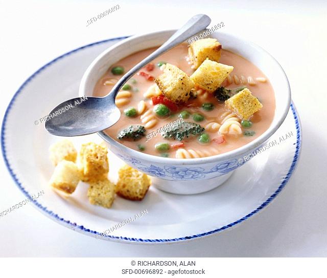 Bowl of Creamy Vegetable Soup with Pasta and Croutons
