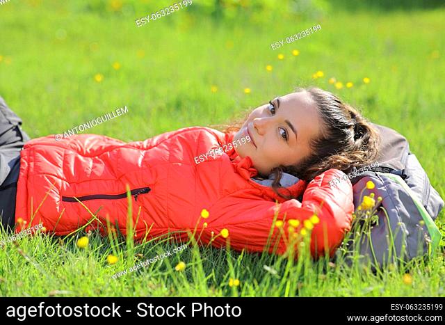 Hiker resting looks at you lying on the grass