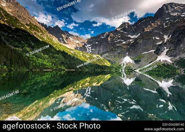 mirror reflection of mountains peaks in alpine lake surface with cristal water. Tatra range in Poland