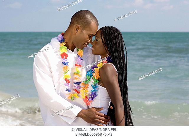 African couple hugging at beach